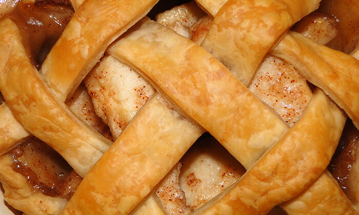 Laced apple pie closeup view with spices