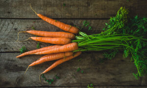 carrots in a bunch on a wooden table