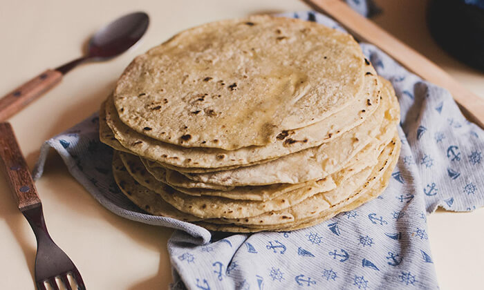 A stack of corn tortillas on a small kitchen towel