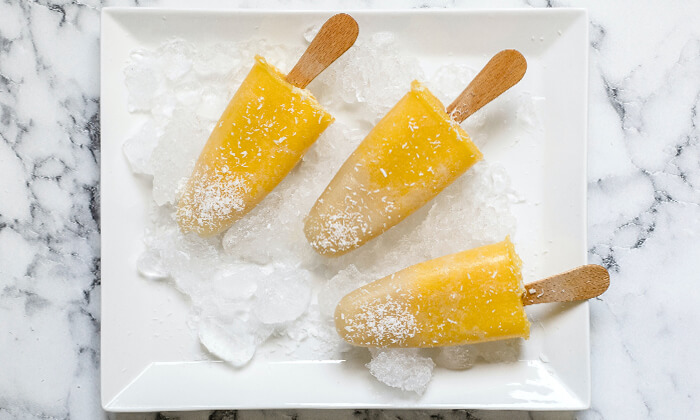 Mango popsicles on a plate with ice