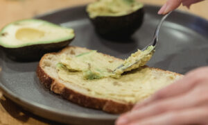 Spreading avocado on toast